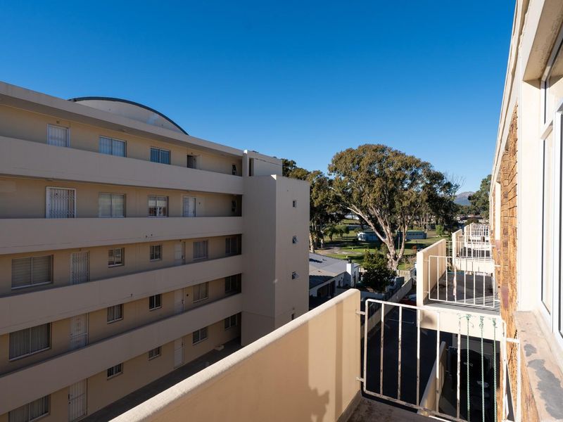 A view from an apartment balcony overlooking the adjacent building complex and surrounding neighborhood area.