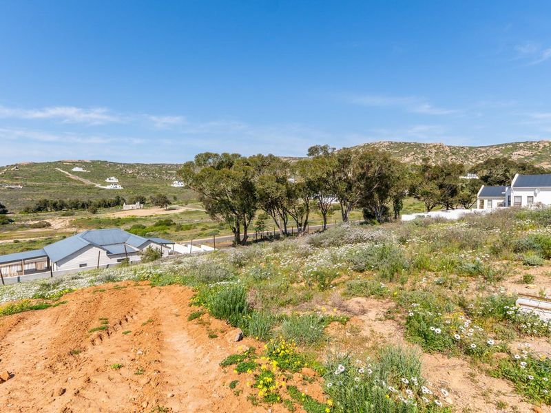A scenic view of the surrounding landscape and neighboring residential properties from the vacant land plot.