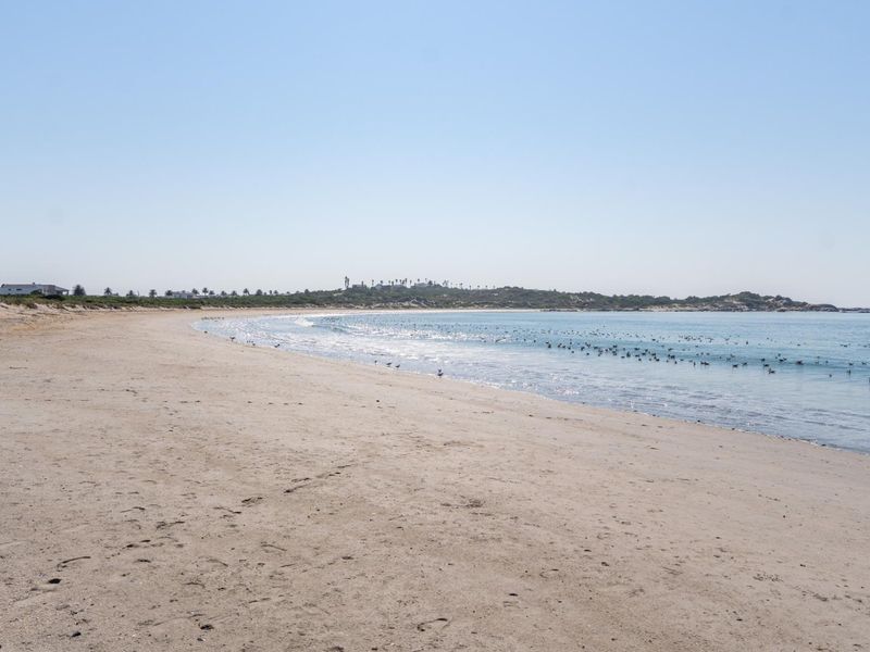 A scenic view of the sandy coastline and ocean, highlighting the natural landscape and beach access adjacent to the property.