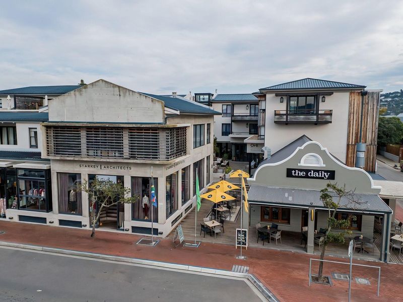 Aerial view of a mixed-use commercial building complex featuring storefronts, timber decking, and modern architectural design elements.