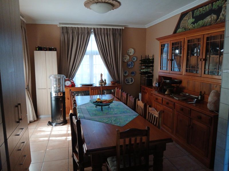 A traditional dining room featuring tiled flooring, built-in wooden cabinetry, and decorative ceiling detailing, providing a warm and functional space for family meals.