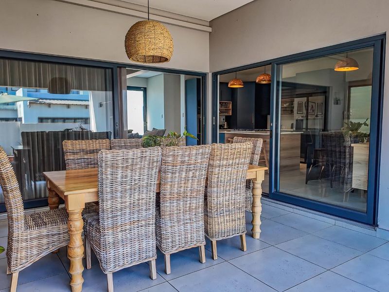 A covered patio area featuring large sliding glass doors that provide seamless access to the interior living space.
