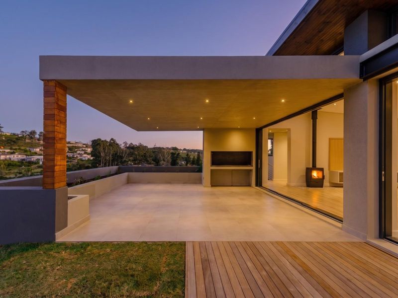 Spacious covered patio featuring built-in braai, recessed lighting, and seamless flow to the interior through large sliding glass doors.