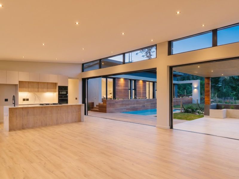 Spacious open-plan living and kitchen area featuring modern cabinetry, integrated appliances, and seamless flow to an outdoor deck and swimming pool.