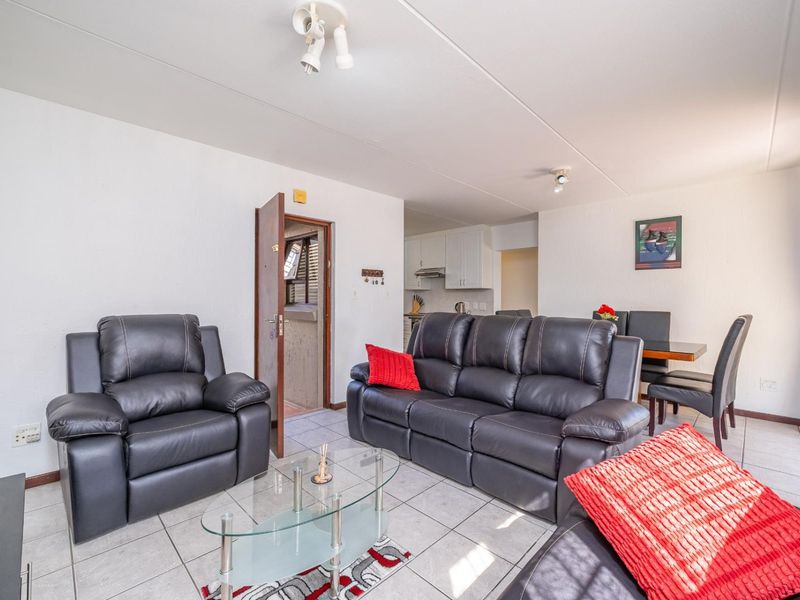 Open plan living and dining area featuring tiled flooring and a view into the adjacent kitchen space.