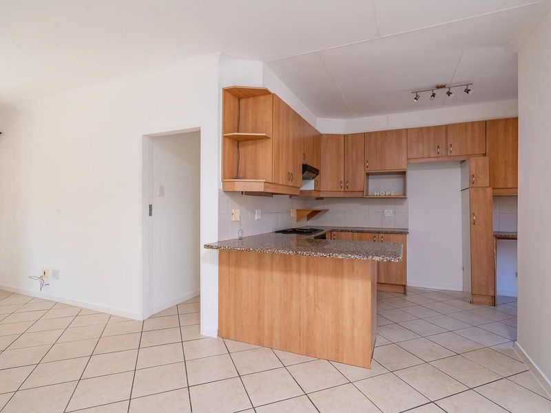Open plan kitchen and living area featuring laminate cabinetry, granite countertops, and ceramic tile flooring throughout.