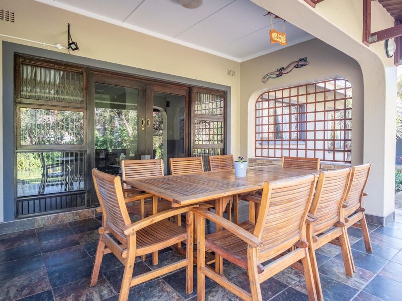 A covered outdoor patio featuring durable tiled flooring and timber-framed sliding doors, providing a seamless transition to the interior living space.