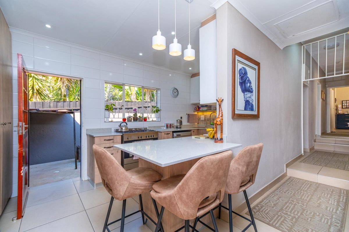 Modern kitchen featuring stone countertops, built-in cabinetry, gas hob, and a breakfast nook, with direct access to an outdoor area.