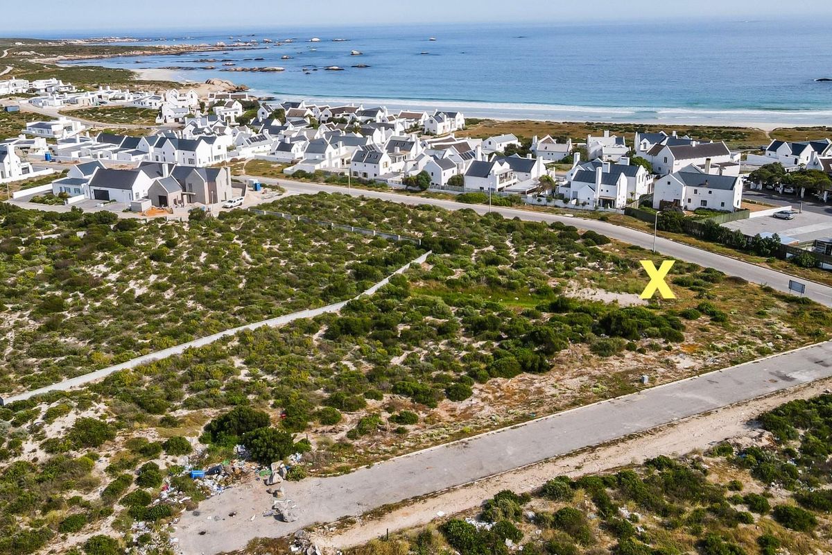 Aerial view of a vacant residential plot situated in a coastal estate, offering proximity to the beach and established neighborhood infrastructure.