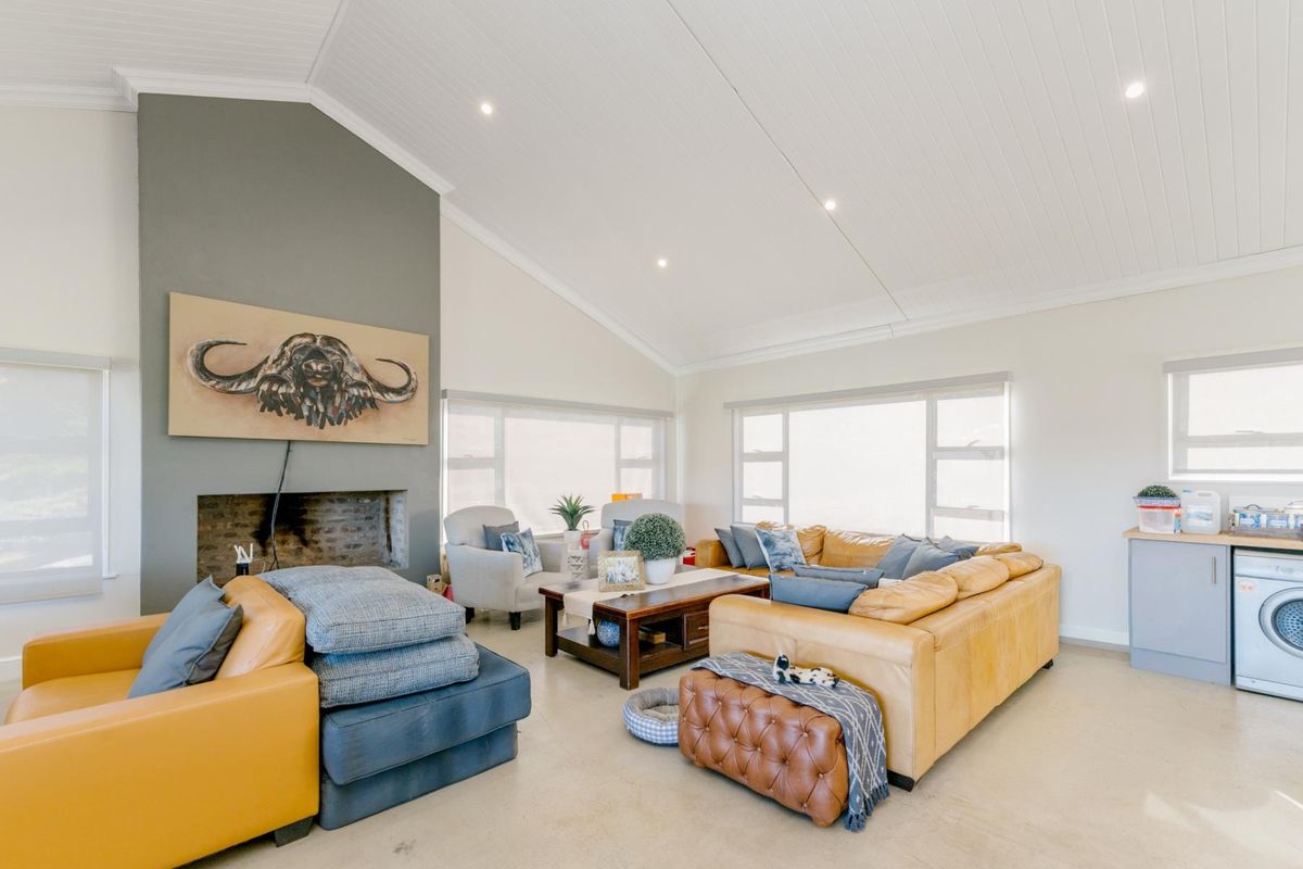 Spacious living room featuring a vaulted ceiling, recessed lighting, and a brick fireplace, creating a bright and comfortable atmosphere.