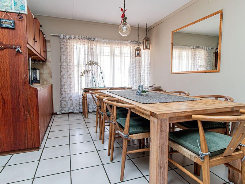 A dining area featuring tiled flooring and built-in wooden cabinetry, providing a functional space for meals and gatherings.