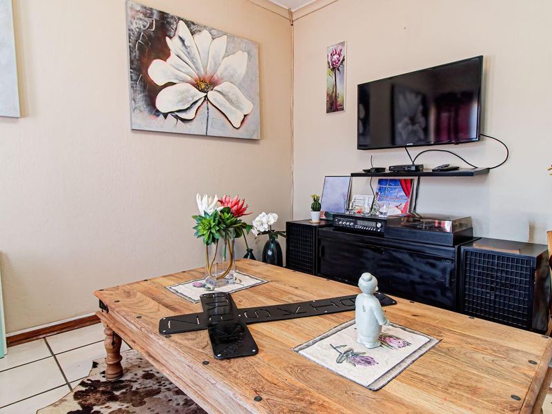 A living room area featuring tiled flooring and neutral wall finishes, providing a functional space for relaxation and entertainment.