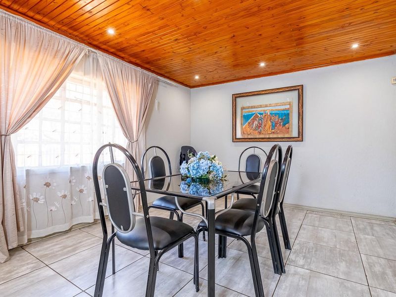 Dining room featuring a warm timber tongue and groove ceiling, recessed downlighting, and neutral ceramic floor tiles.