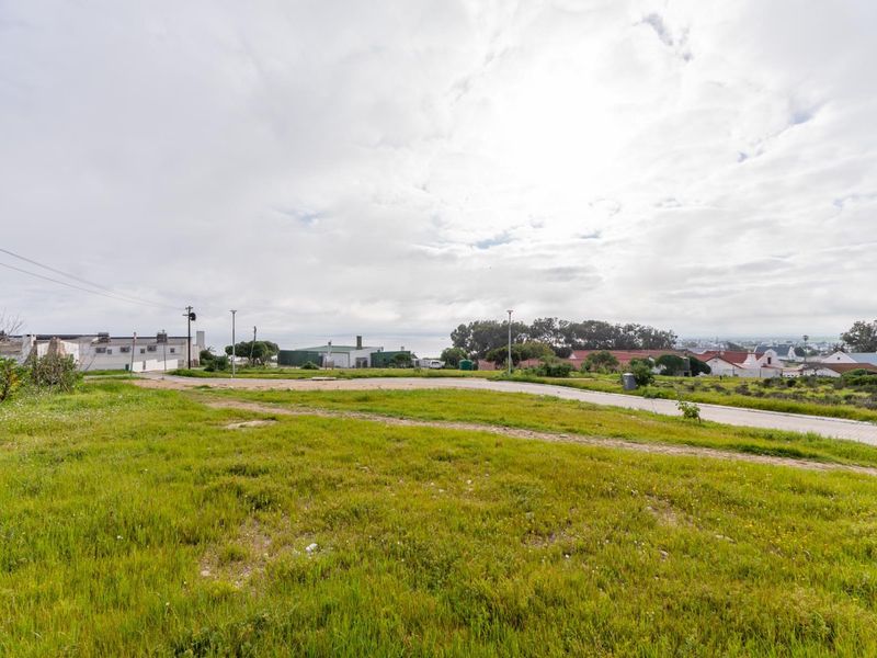 A view of the street and surrounding residential neighborhood, showcasing the vacant land's access and local environment.