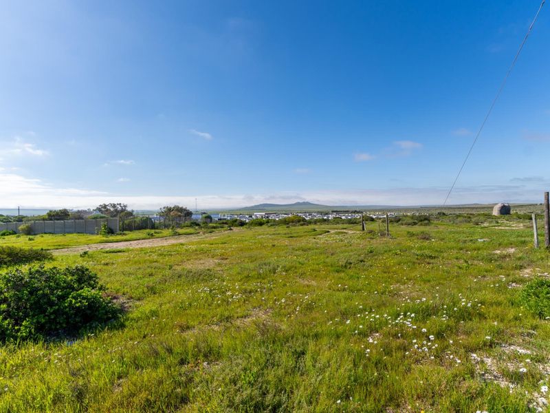 A wide-angle view of the vacant residential land, showcasing the natural landscape, surrounding terrain, and distant horizon.