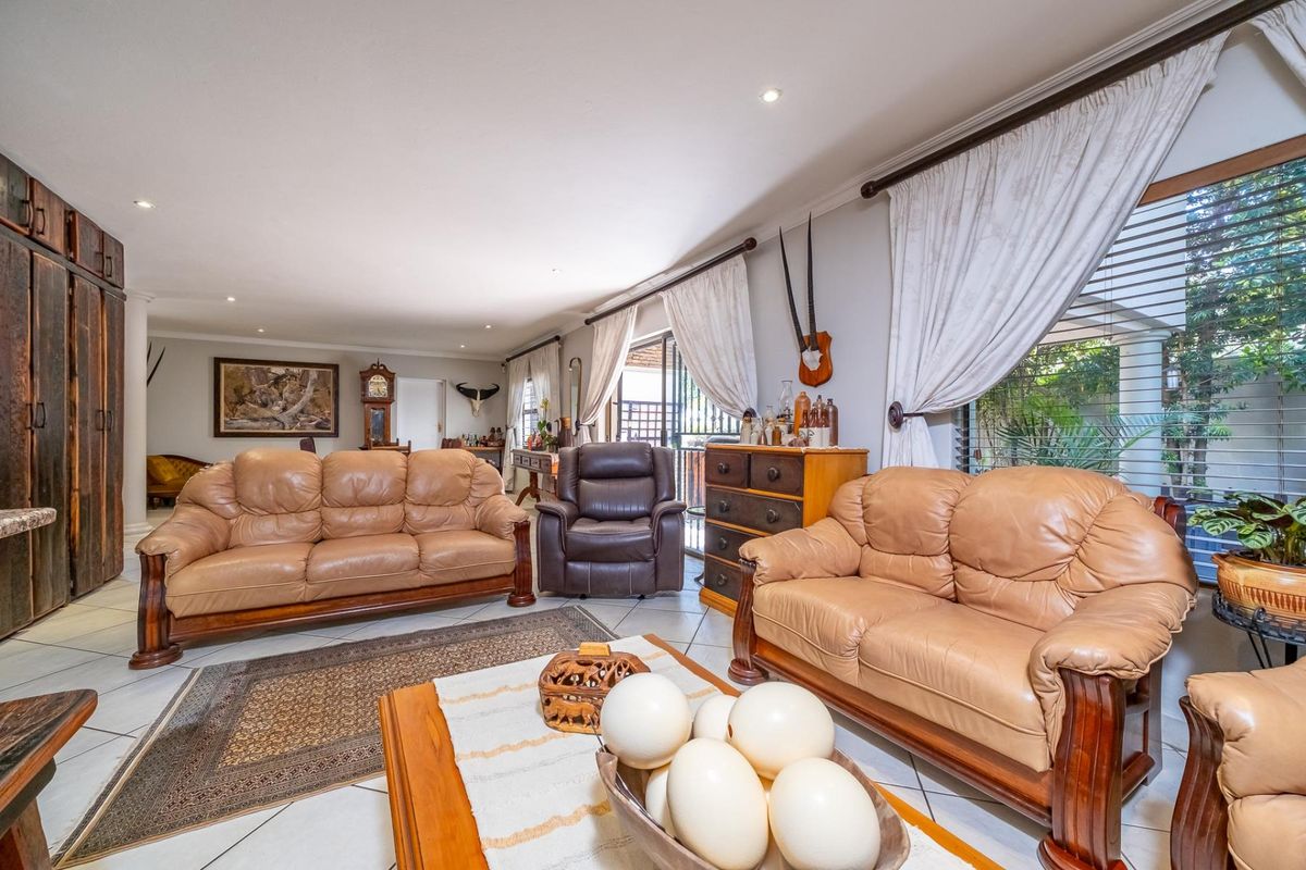 Spacious living room featuring tiled flooring, recessed lighting, and large sliding glass doors providing access to the outdoor area.