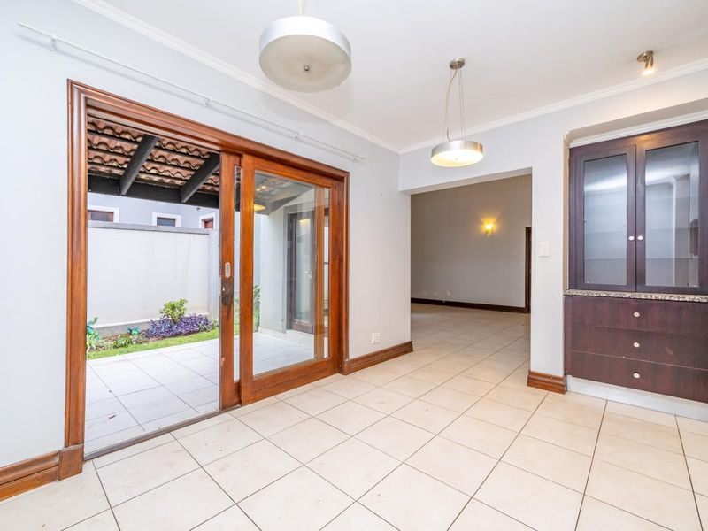 Open plan living area featuring tiled floors, built-in cabinetry with granite surfaces, and sliding glass doors leading to a private patio.
