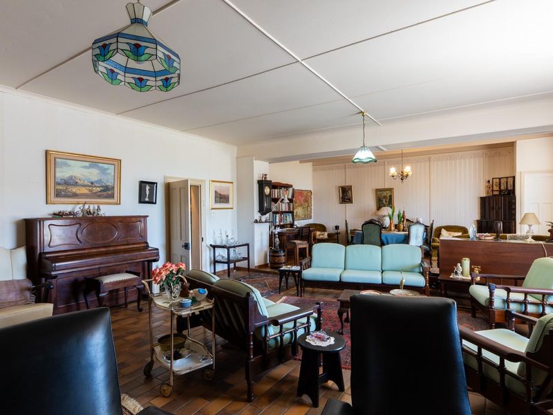 Spacious open-plan living and dining area featuring tiled flooring and traditional ceiling panels, offering a versatile layout for family living and entertaining.