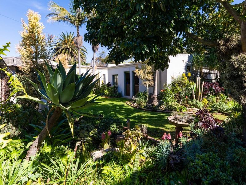 A lush, well-established garden featuring mature trees, a manicured lawn, and diverse plantings, providing a serene outdoor space.