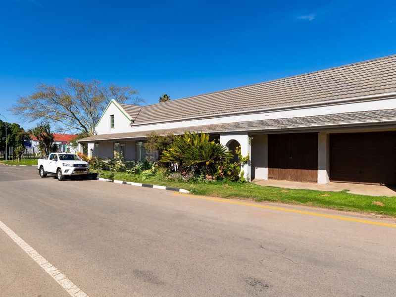 Street-facing view of a single-story house featuring a tiled roof, double garage, and a covered entrance area.