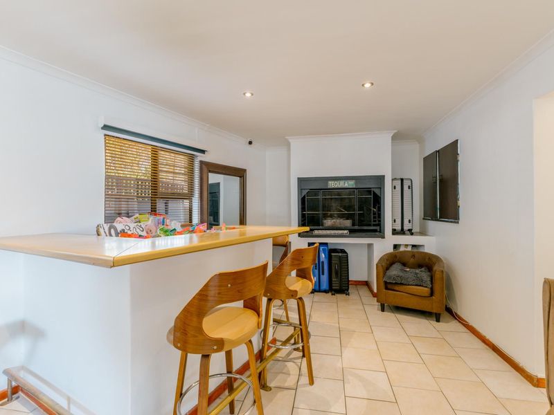A dedicated bar area featuring a built-in counter, tiled flooring, and a built-in fireplace, offering a functional space for entertainment.