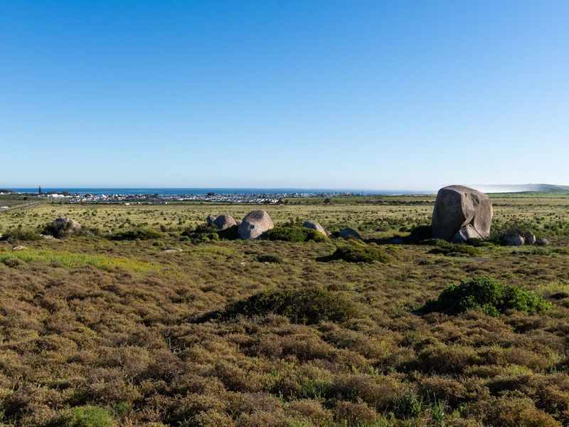 Expansive view of the coastal landscape featuring natural rock formations and distant ocean horizon.
