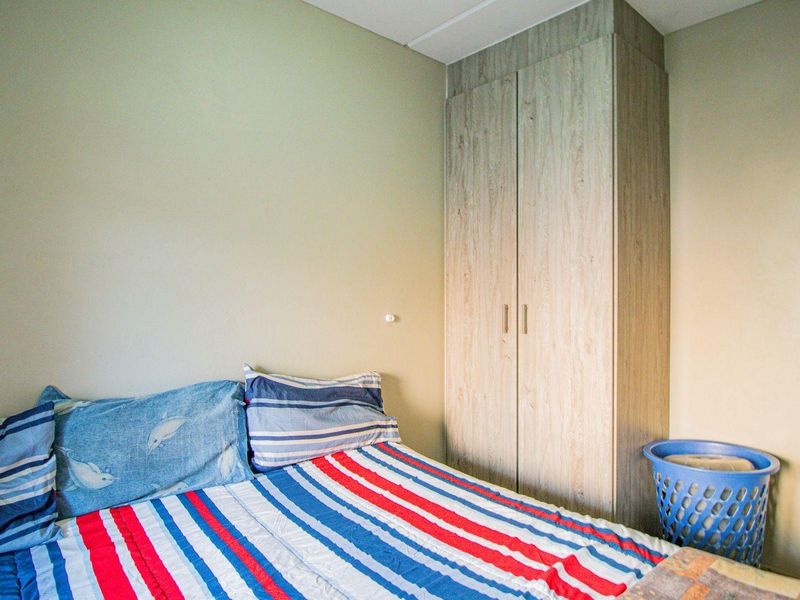 A bedroom featuring a light wood-finish built-in wardrobe providing integrated storage space.