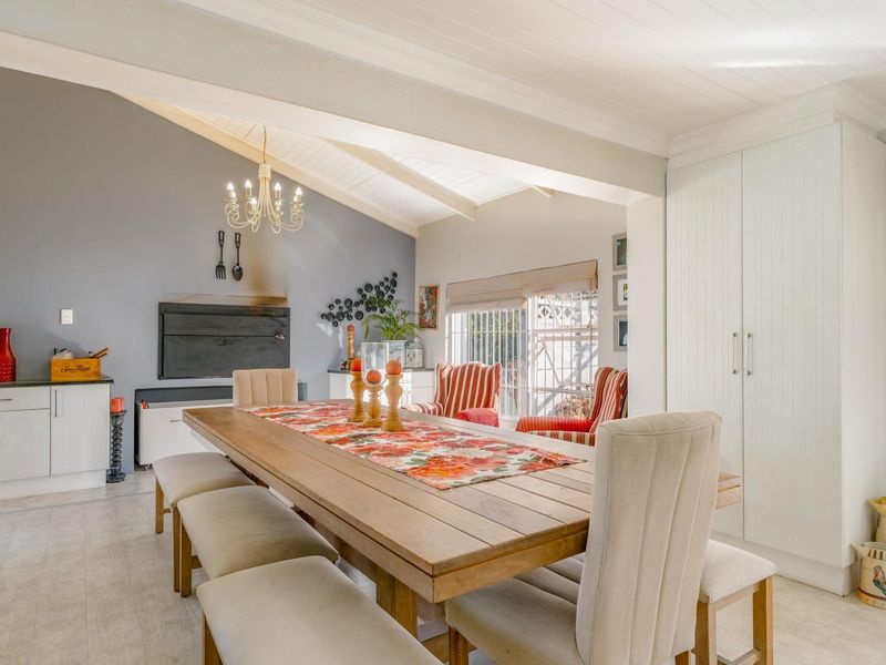 Spacious open-plan dining area featuring a vaulted ceiling, built-in fireplace, and integrated cabinetry, creating a bright and functional living space.