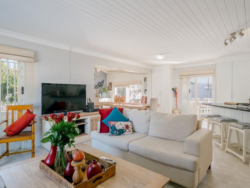 Spacious open-plan living area featuring a modern kitchen with breakfast bar, granite countertops, and a bright, airy atmosphere with tongue and groove ceilings.