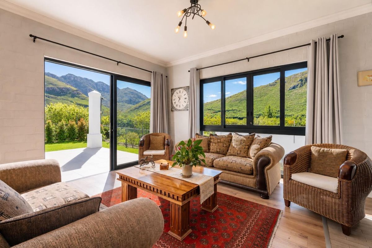 Bright living room featuring large sliding doors and windows with mountain views, laminate flooring, and modern lighting fixtures.