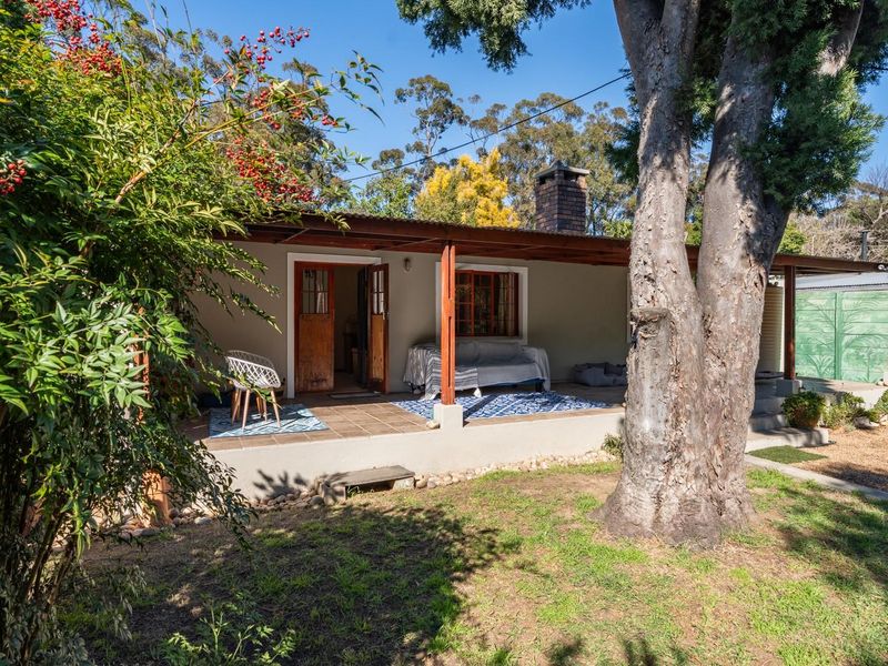 A covered outdoor patio area featuring tiled flooring and a brick chimney, providing a functional space for outdoor relaxation and entertainment.