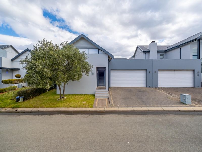Front elevation of a modern residential property featuring a double garage, paved driveway, and a clean, contemporary facade.
