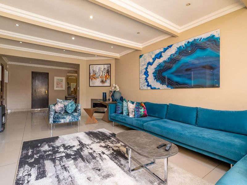 Spacious living room featuring tiled flooring, a coffered ceiling with recessed lighting, and a built-in fireplace.