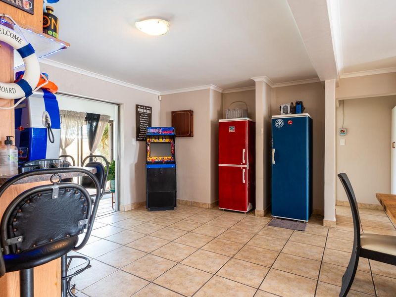 A casual bar area featuring tiled flooring, a built-in bar counter, and direct access to an outdoor patio through a sliding glass door.