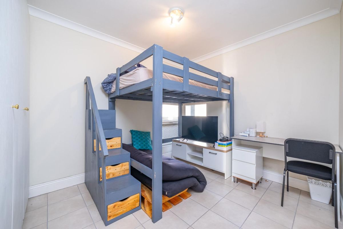 A bedroom featuring tiled flooring and coving, currently utilized with a loft bed configuration.