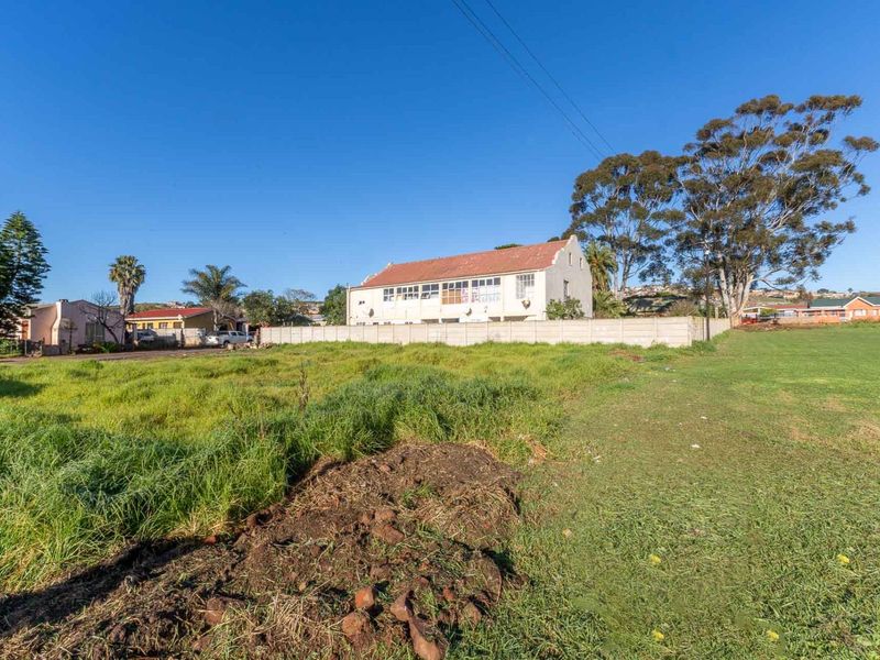 A vacant residential plot featuring grassed land and a precast concrete boundary wall, offering potential for development in a established neighbourhood.