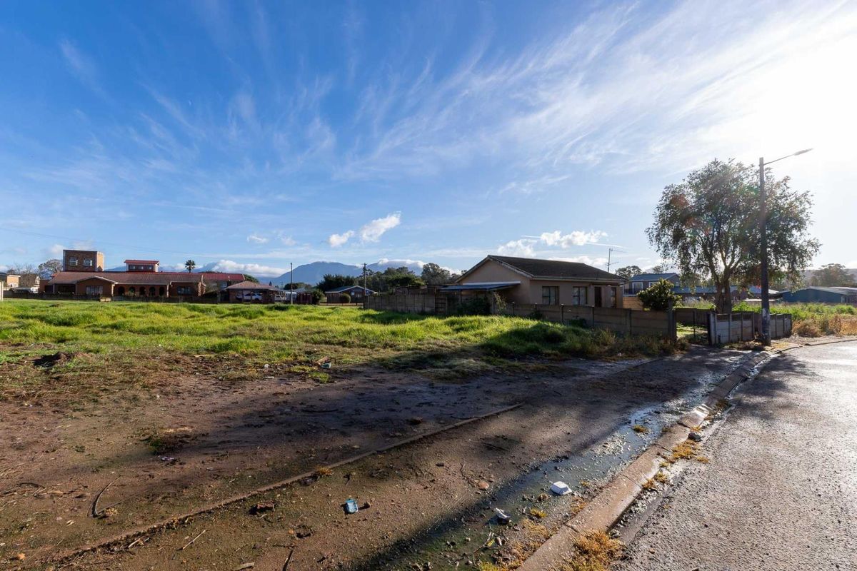 A vacant residential plot featuring an unimproved surface, street access, and surrounding neighborhood views.