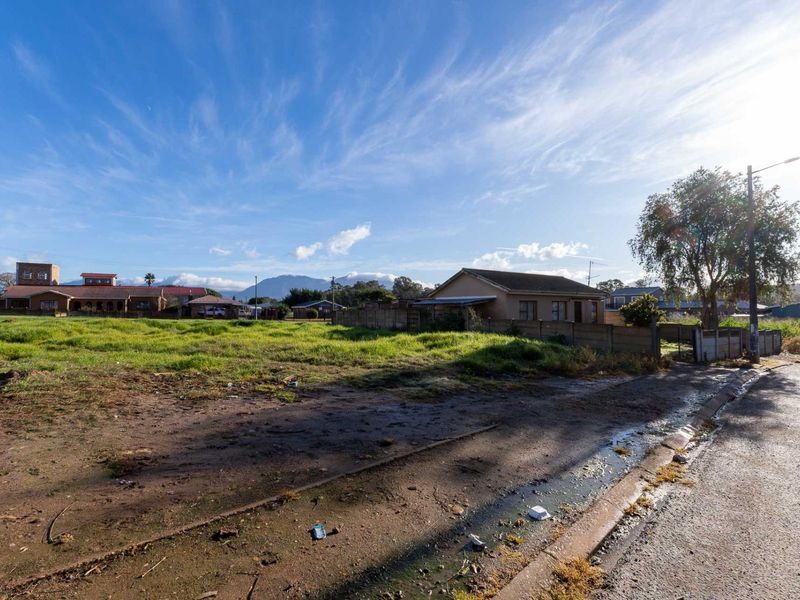 A vacant residential plot featuring an unimproved surface, street access, and surrounding neighborhood views.