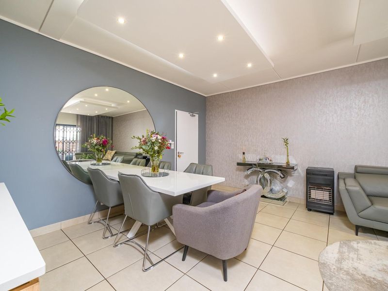 A well-maintained living area featuring tiled flooring, recessed ceiling lighting, and a modern feature wall, creating a bright and inviting space.