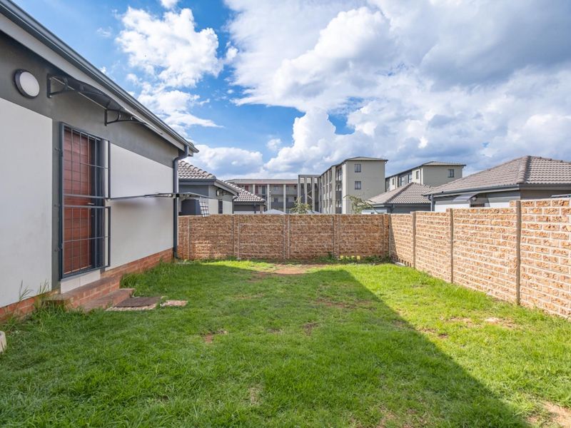 A private rear garden featuring a lawn area enclosed by a brick boundary wall, providing a secure outdoor space.