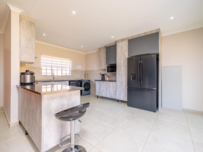 Modern kitchen featuring granite countertops, ample built-in cabinetry, tiled flooring, and recessed lighting, offering a clean and functional workspace.