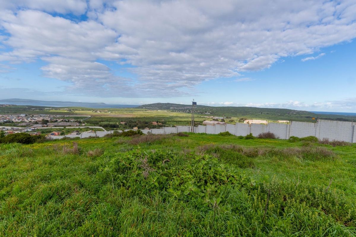 A wide-angle view of the vacant residential land, featuring a perimeter wall with electric fencing and expansive landscape views.
