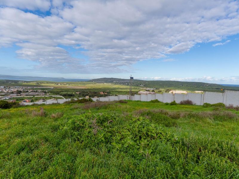 A wide-angle view of the vacant residential land, featuring a perimeter wall with electric fencing and expansive landscape views.