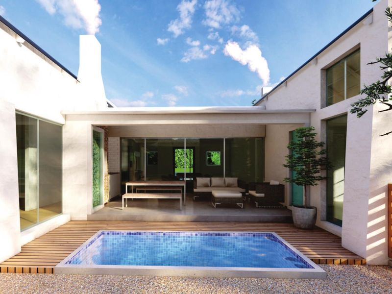 A modern outdoor living space featuring a swimming pool, timber decking, and a covered patio area with integrated chimney.