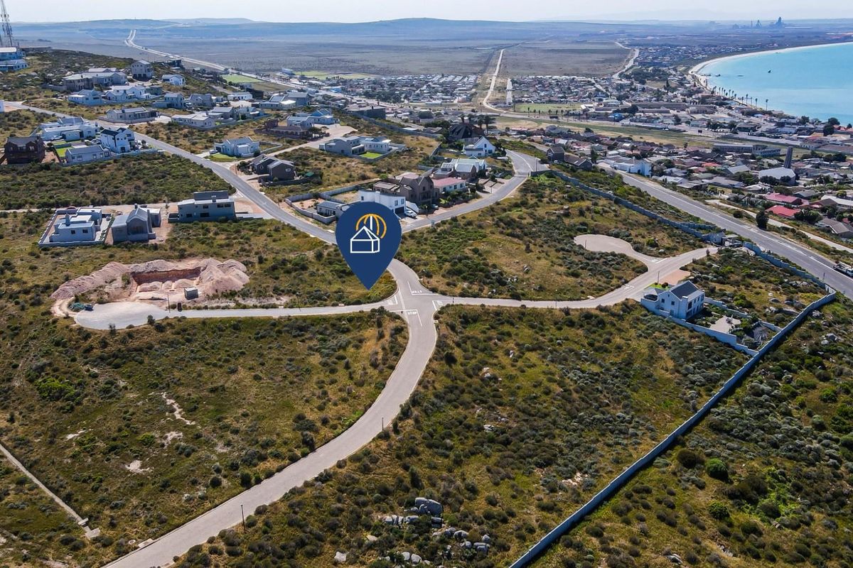 An aerial view of a residential development site featuring paved roads and surrounding coastal landscape in a prime location.