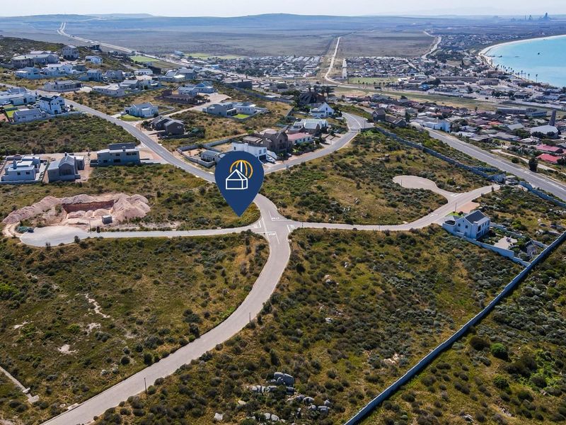An aerial view of a residential development site featuring paved roads and surrounding coastal landscape in a prime location.