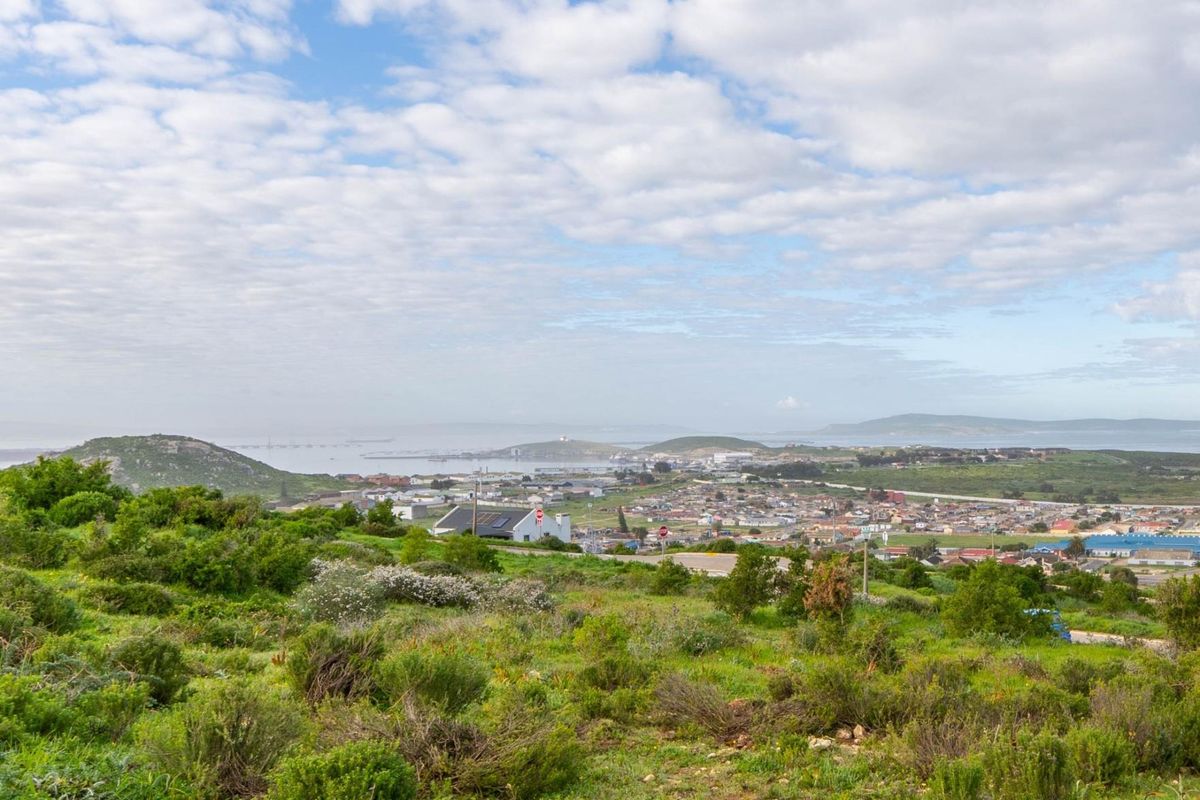 An elevated panoramic view overlooking the coastal town, bay, and surrounding natural landscape.
