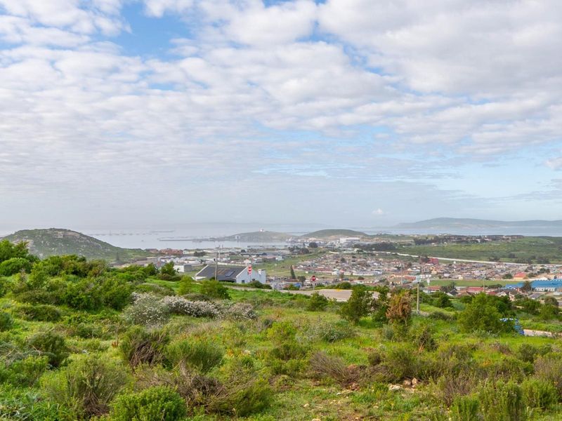 An elevated panoramic view overlooking the coastal town, bay, and surrounding natural landscape.