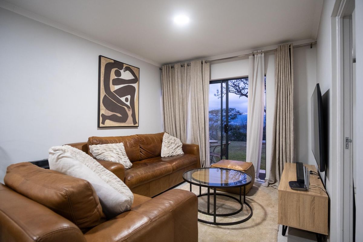 A comfortable living room featuring a sliding glass door that provides access to the outdoors and allows for natural light.