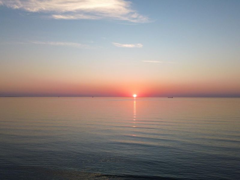 A scenic sunset view over the calm ocean horizon, highlighting the natural landscape and coastal setting of the property.